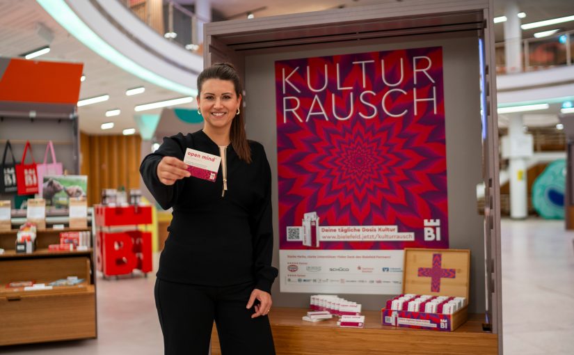 Projektleiterin Nadine Connor präsentiert die Kulturrausch-Kampagne in der neuen Tourist-Information in der Wissenswerkstadt an der Wilhelmstraße 3, wo es zu jedem Ticket eine Packung mit „open mind“-Pastillen für kulturelle Nebenwirkungen gibt. (Foto: Bielefeld Marketing | Adrian Stein)