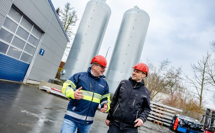 Frank Wehrmann (links), Geschäftsführer von Wehrmann Transport, und Gebäudemanager Matthias Gering inspizieren die beiden Pufferspeicher, die mit elf Metern Höhe jeweils ein Volumen von 45.000 Litern fassen. (Foto: Simone Reukauf)